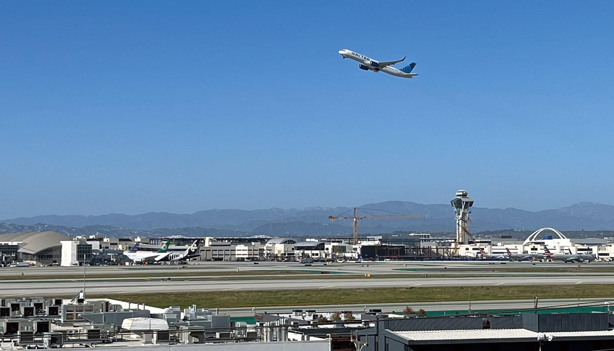 空港全景、ターミナル工事のクレーンが見える