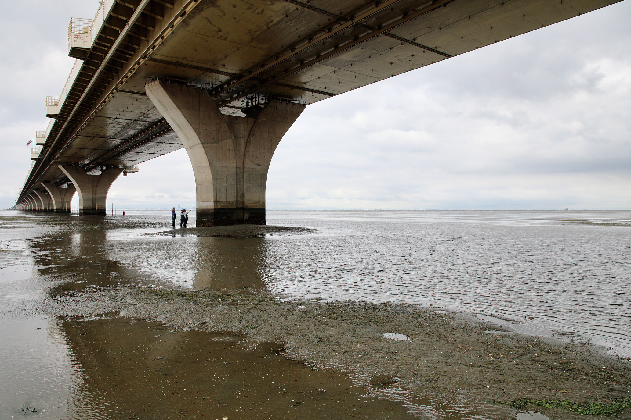写真集『アクアライン』より。潮が引いた日の橋脚の点検作業中の姿。人の手、人の目で